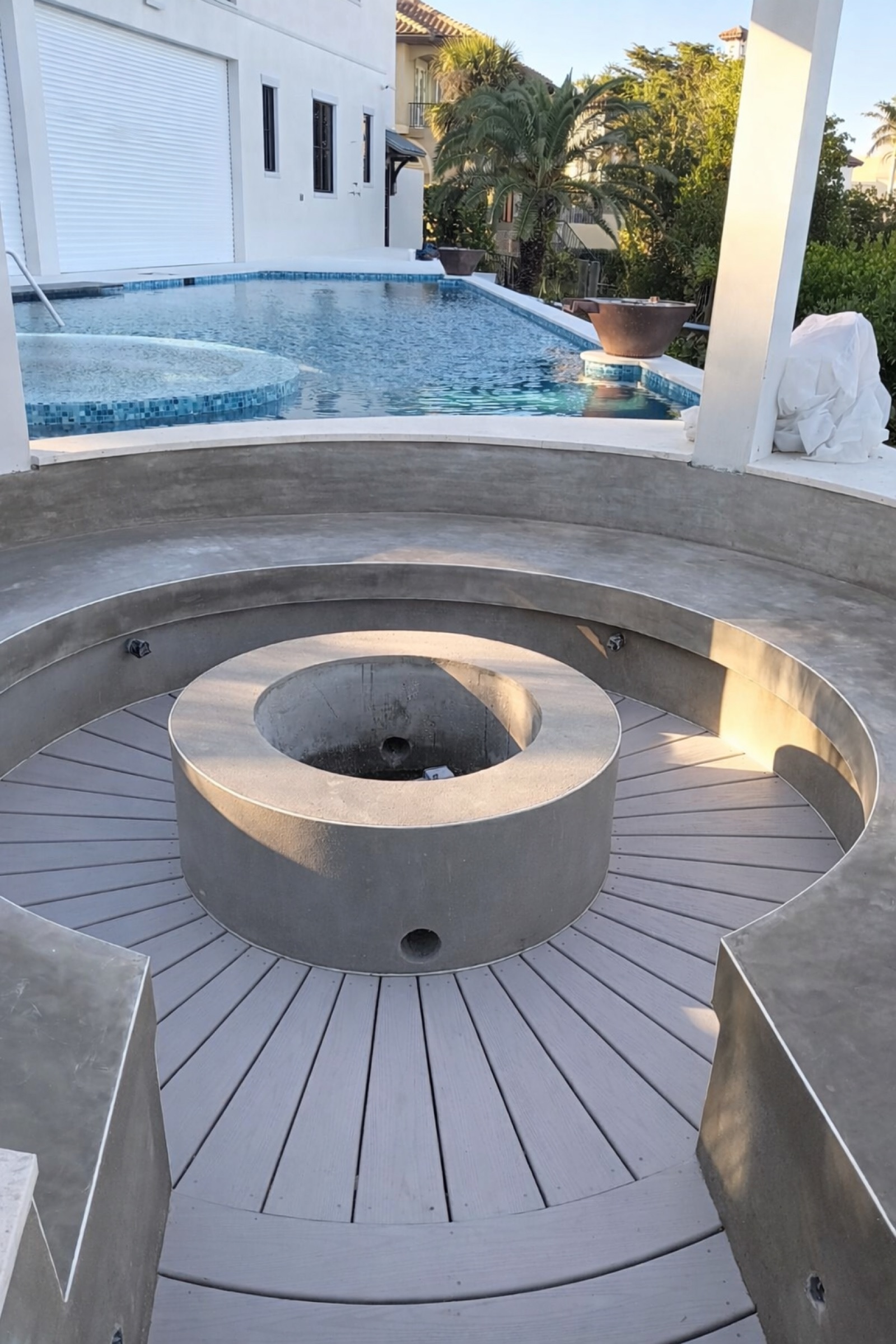 Custom stucco firepit and bench overlooking pool